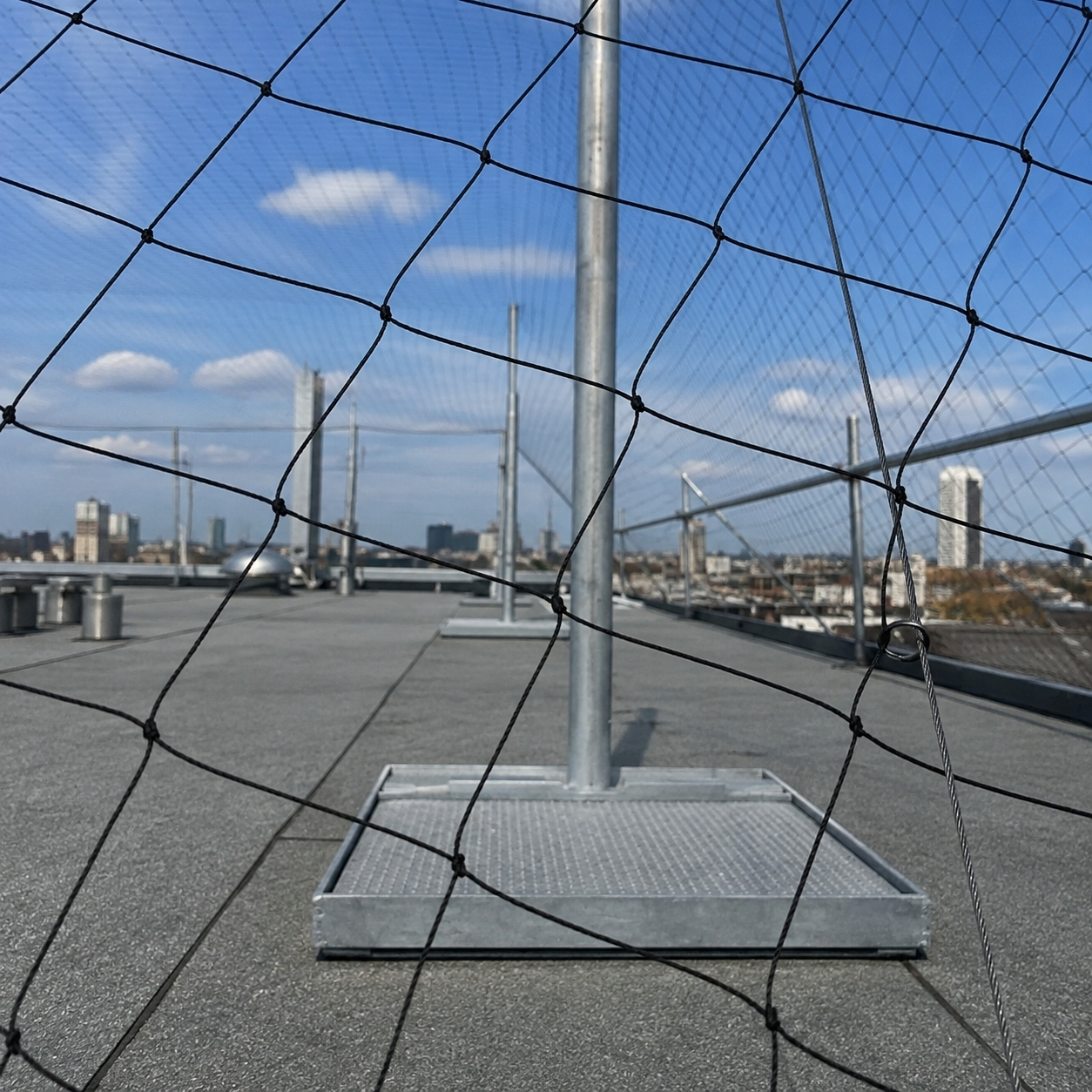Hawk successful installation of bird netting on top of commercial roof to deter seagulls and pigeons from nesting and contaminating the property.
